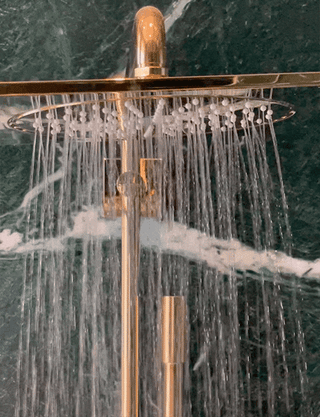 Woman rinsing ANSWR shampoo in shower